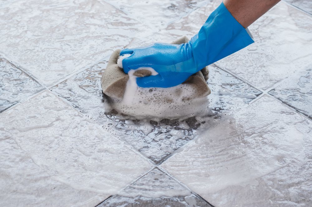 Technician performing tile floor cleaning