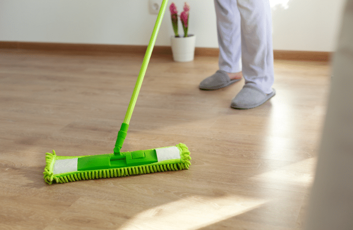 Laminate floor cleaning - person sweeping laminate floor