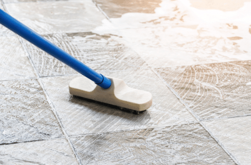 Floor tile cleaning service - contractor mopping floor tiles